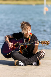 Man playing guitar at beach