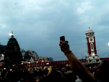 People photographing against sky in city