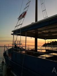 Boat moored on sea against clear sky during sunset