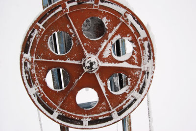 Close-up of clock on snow over white background