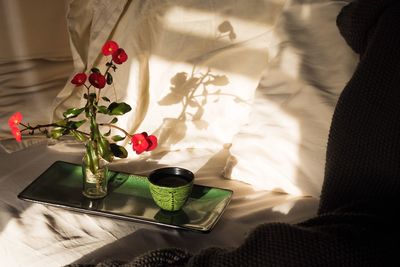 High angle view of tea and flowers on bed