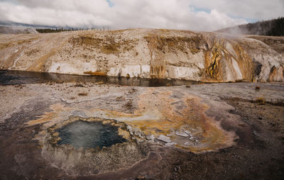 Scenic view of geothermal land against sky