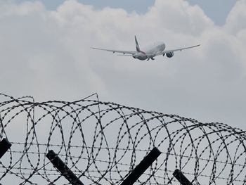 Low angle view of airplane flying against sky