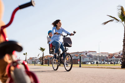 Man riding bicycle on road against sky