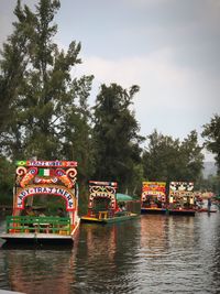 Multi colored boats in water against sky