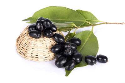 Close-up of grapes in basket over white background