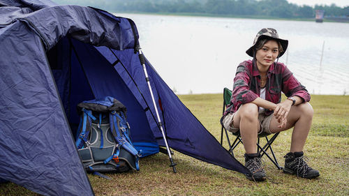 Full length of young woman sitting on tent