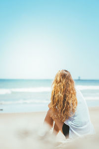 Woman walking on beach against sky