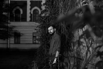 Portrait of young man standing by tree