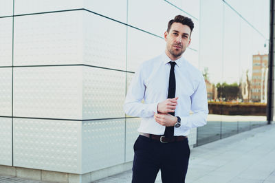 Young man standing against wall