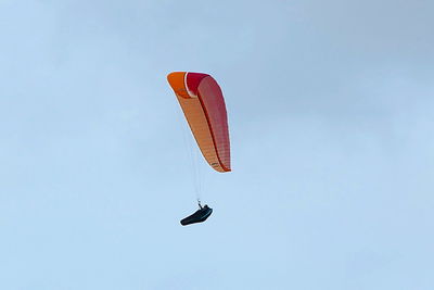 Low angle view of person paragliding against sky