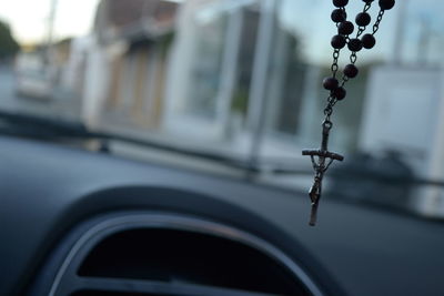 Close-up of crucifix hanging in car