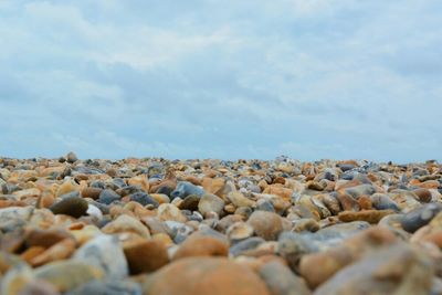 Surface level of rocks against cloudy sky