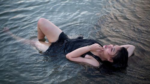 High angle view of woman lying in water