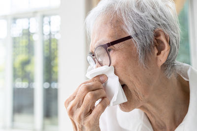 Senior woman blowing nose