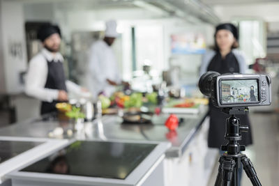 Chefs vlogging through camera at restaurant