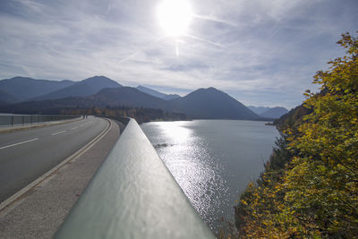 Scenic view of road by mountains against sky