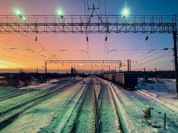 Train at railroad station against sky during sunset