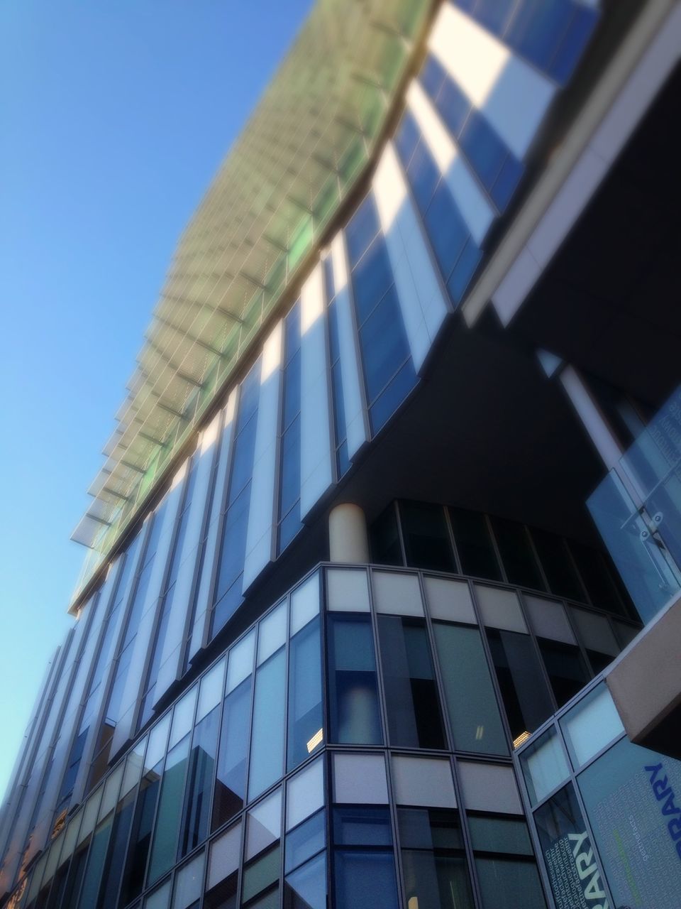 architecture, low angle view, building exterior, built structure, modern, office building, skyscraper, tall - high, city, building, tower, clear sky, glass - material, reflection, blue, day, sky, architectural feature, outdoors, no people