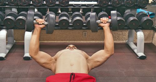 Shirtless man exercising at gym