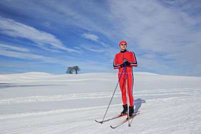 Full length of man skiing on snowy field against sky