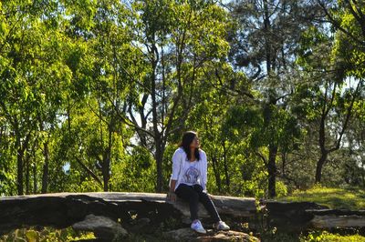 Rear view of young man standing against trees