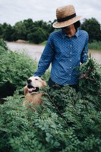 Woman standing with dog amidst plants