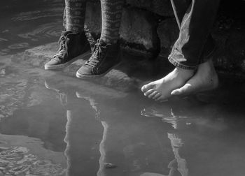 Low section of woman standing on water