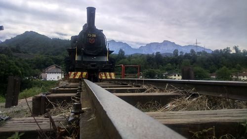 Train by railroad tracks against sky