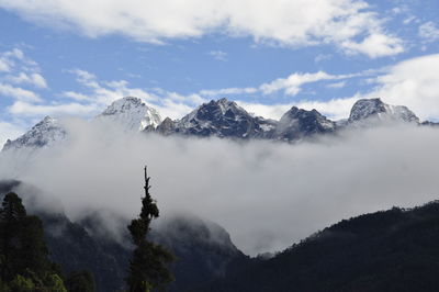 Scenic view of snowcapped mountains against cloudy sky