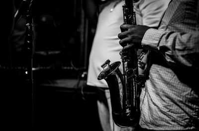 Midsection of male musician playing saxophone