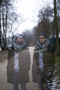 Multiple image of young man standing on footpath against trees and sky