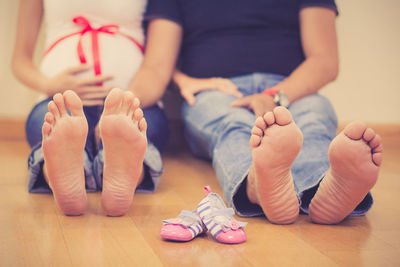 Low section of couple sitting on floor at home