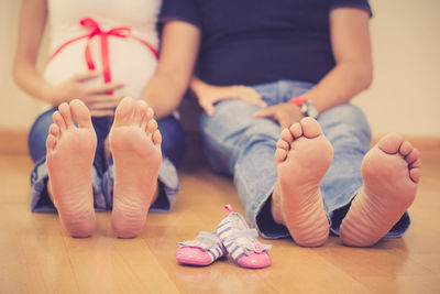 Low section of couple sitting on floor at home