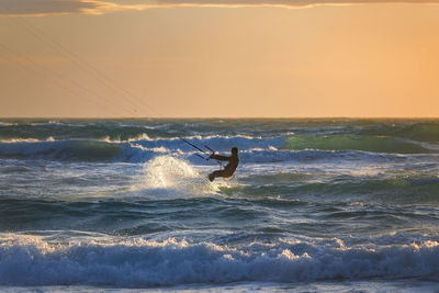 Man surfing in sea against sky