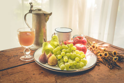 Close-up of fruits and drink on table at home