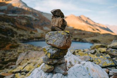 Close-up of stones stacked on rocks against sky