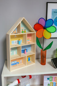Sustainable house model and pinwheel over shelf in classroom