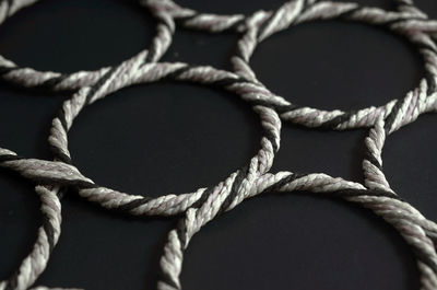Close-up of patterned ropes on black background