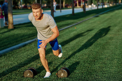 Full length of young man exercising on field