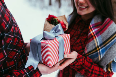 Hands giving a gift box with ribbon. blurred background. high quality photo