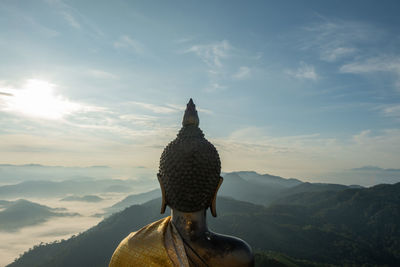 Statue of cross on mountain against sky