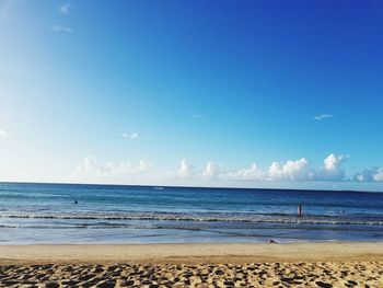 Scenic view of beach against blue sky