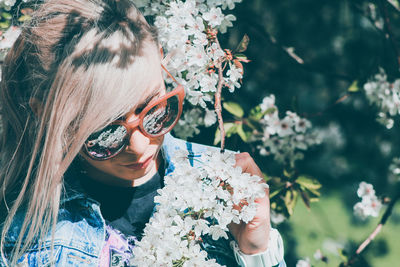 Portrait of woman wearing sunglasses against plants