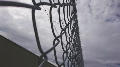 Close-up of chainlink fence against sky