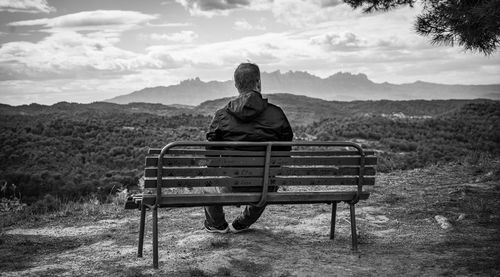 Rear view of woman sitting on bench