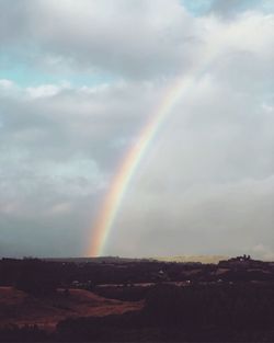 Scenic view of rainbow over landscape against sky