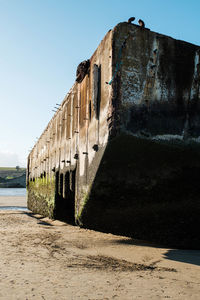 Old ruin on beach against clear sky