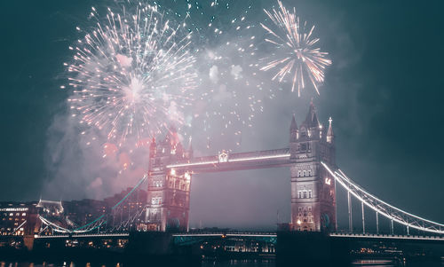 Low angle view of illuminated firework display at night