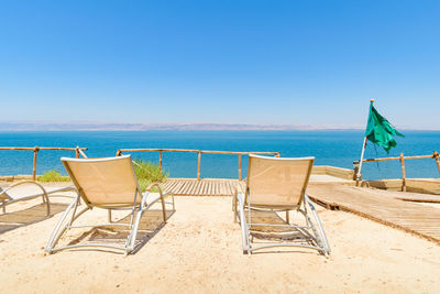 Sun beds on beach resort terrace over dead sea and israel, madaba, jordan, middle east